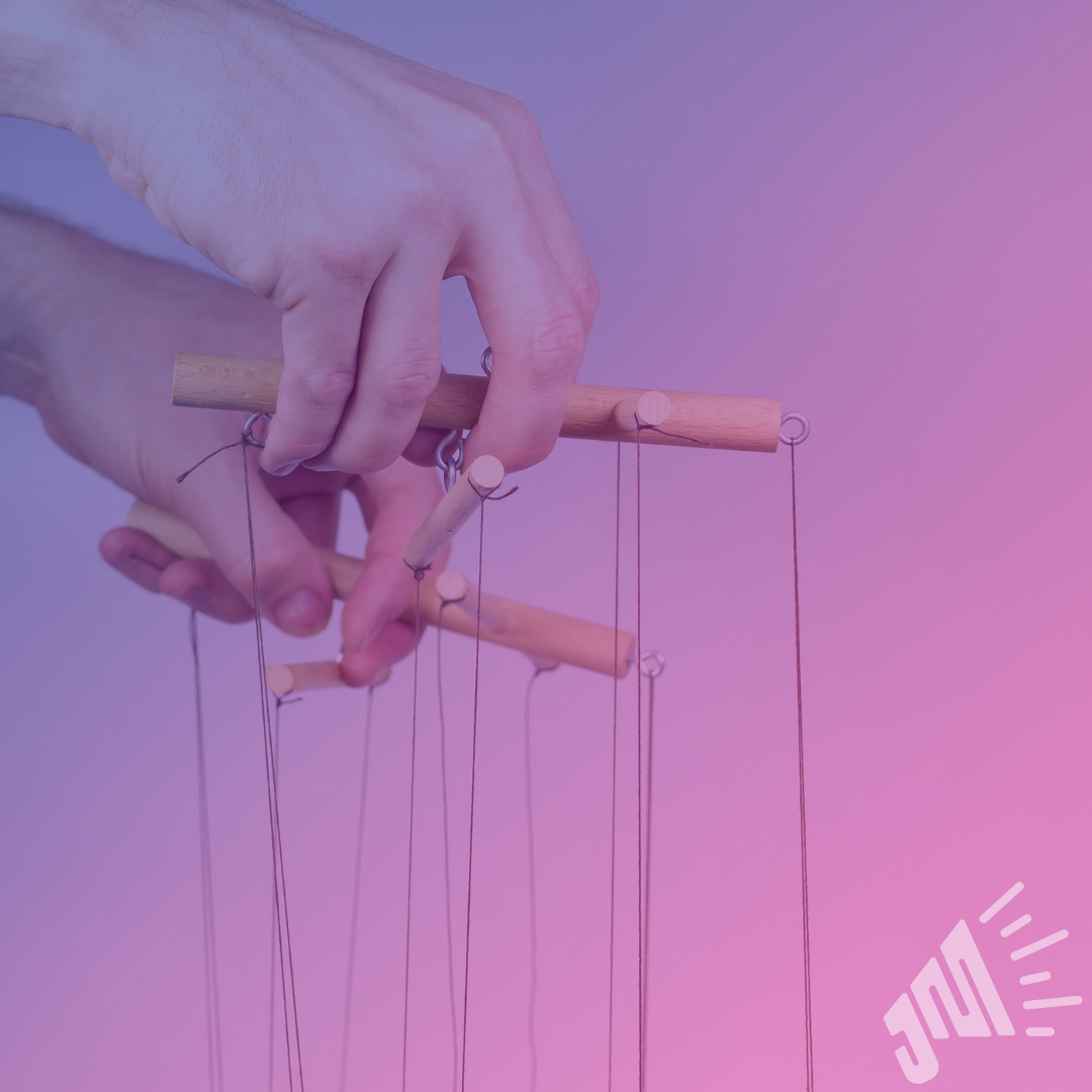 Two hands are holding marionette puppets on strings. The image has a gradient overlay of purple and pink.
